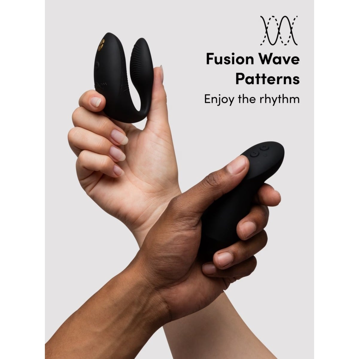 Two hands holding black electronic toy with 'Fusion Wave Patterns' branding on a light gray background.